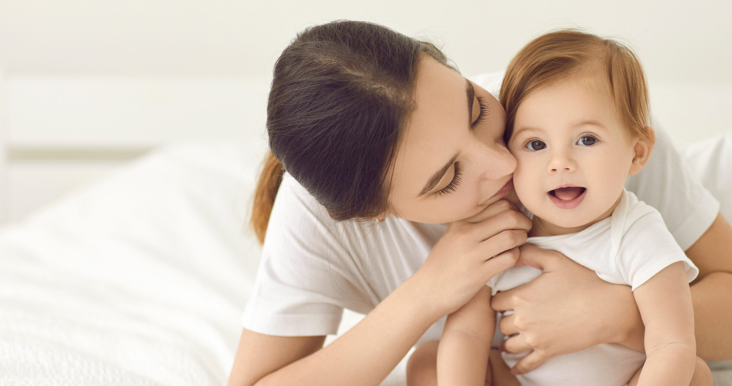 Mãe com o filho no colo em casa, representando a maternidade neurodivergente no puerpério