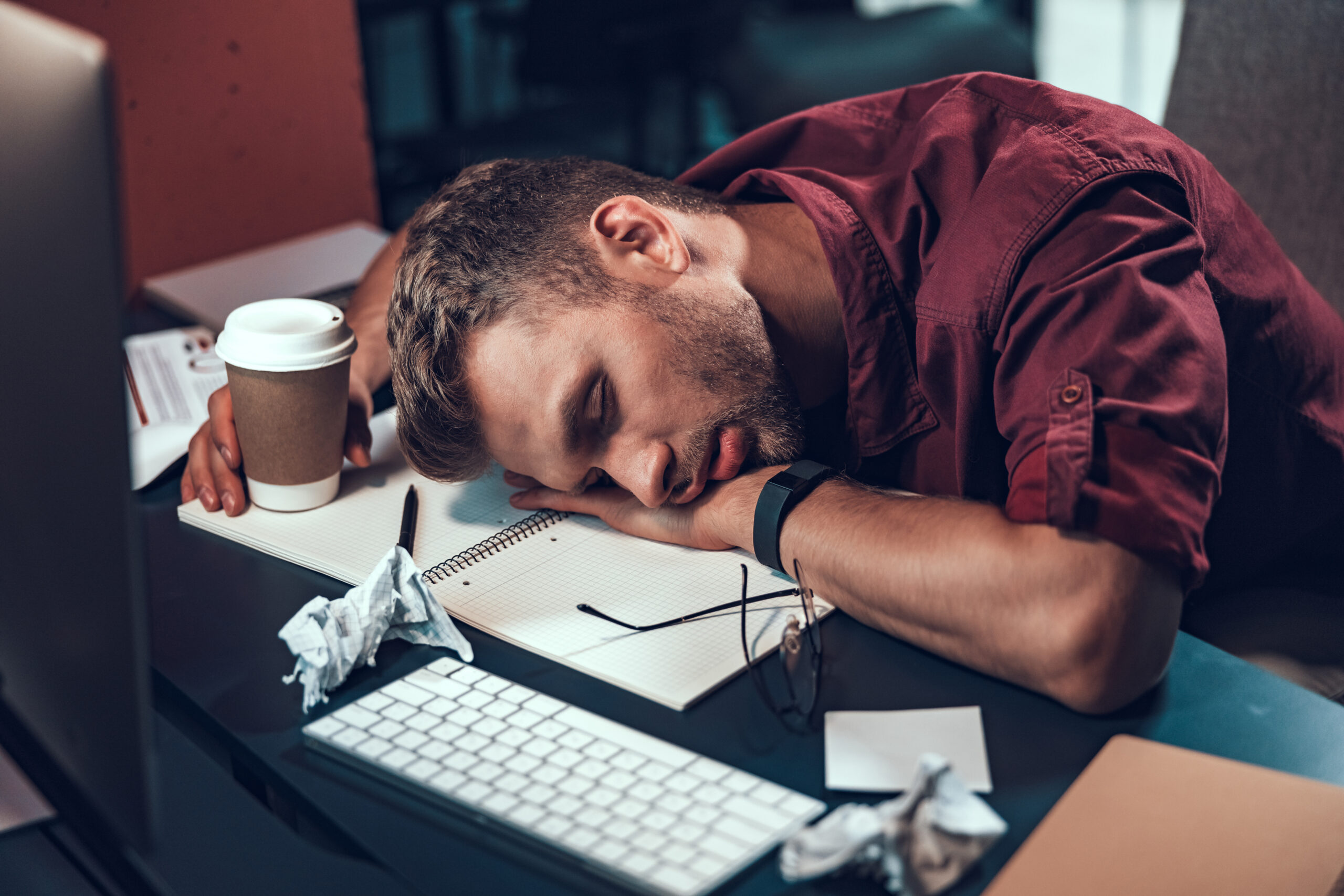 Profissional cansado apoiado na mesa, ilustrando o burnout e o esgotamento profissional