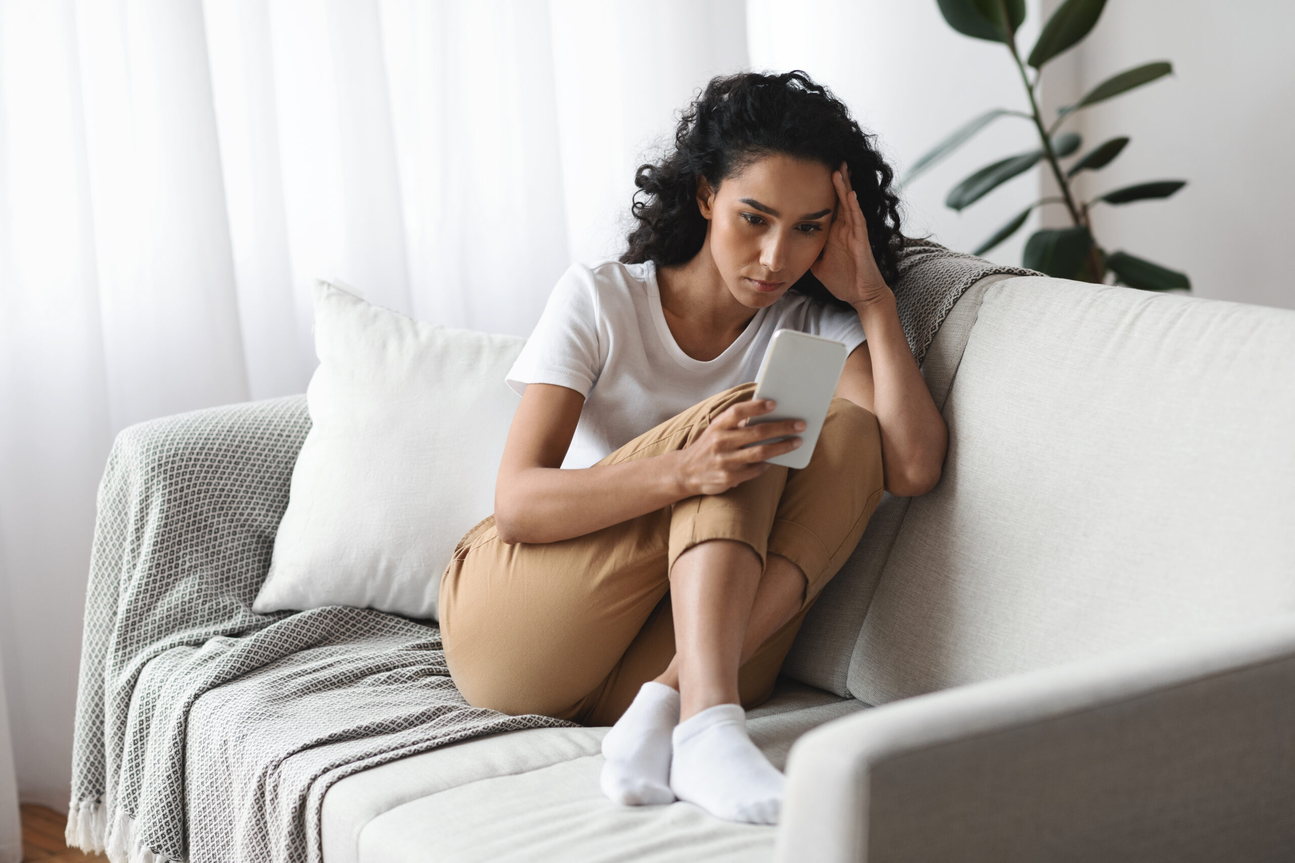 Mulher preocupada olhando a tela do celular representando ansiedade de saúde