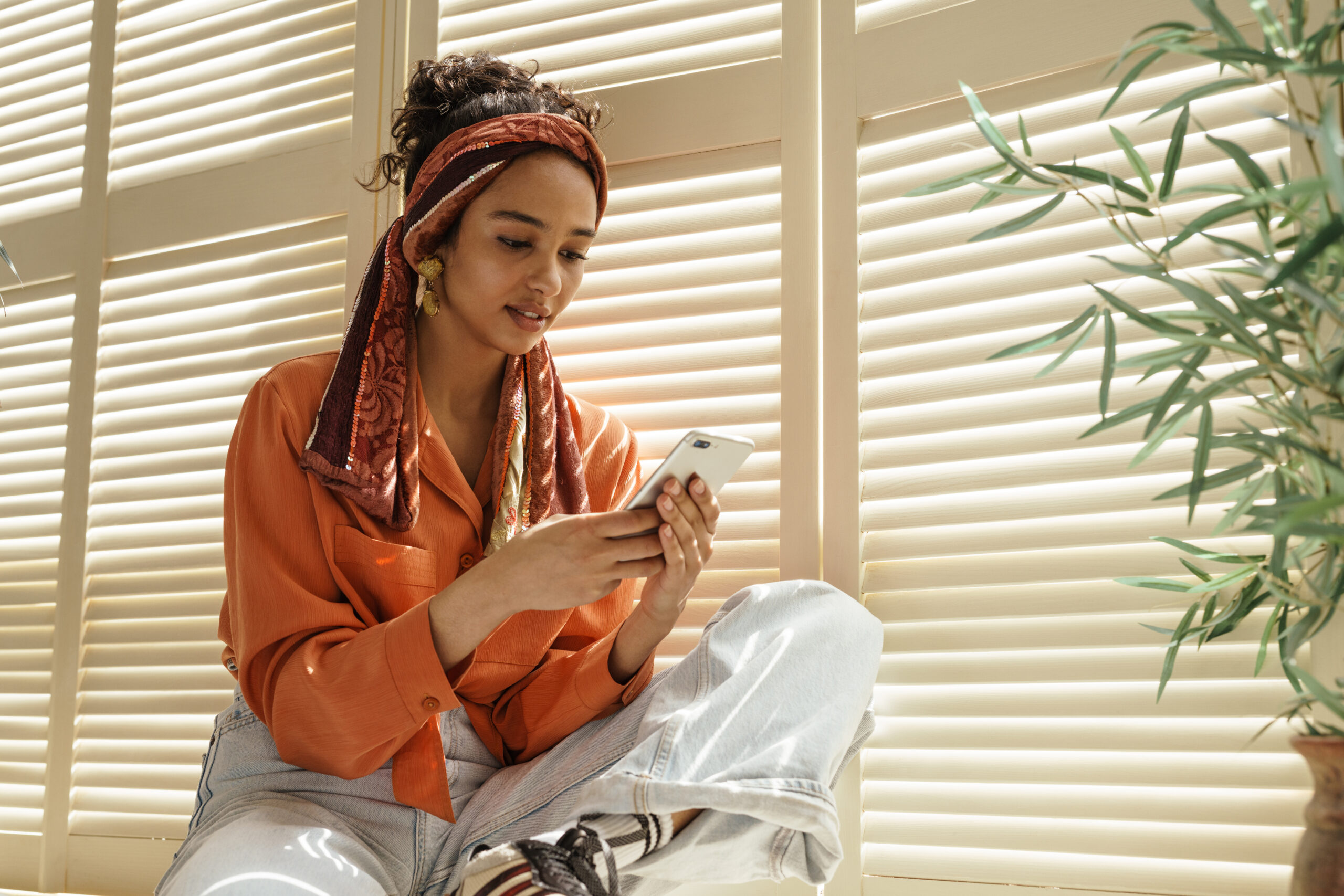 Mulher com celular junto à janela representando disforia sensível à rejeição