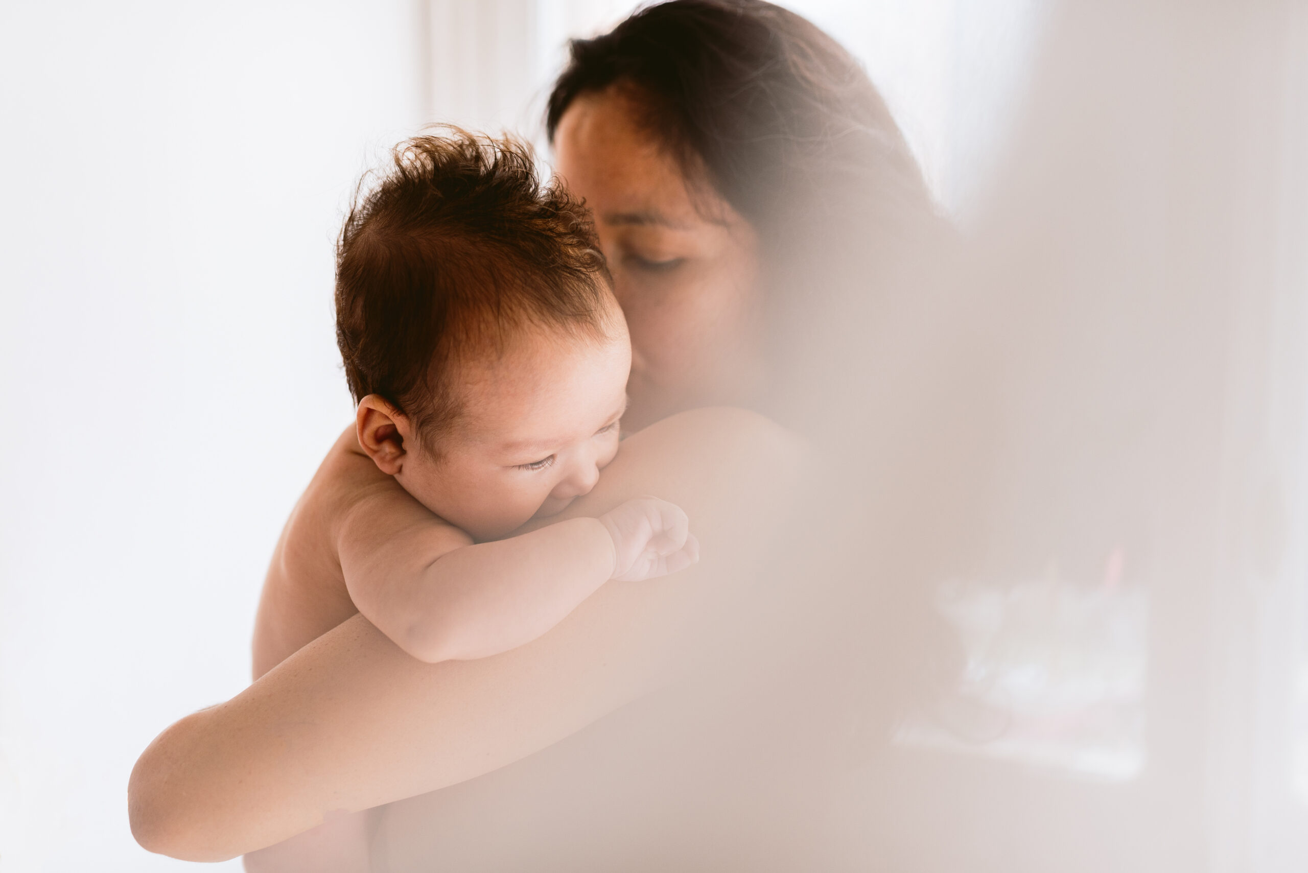 Mãe com recém-nascido em luz suave ilustrando matrescência